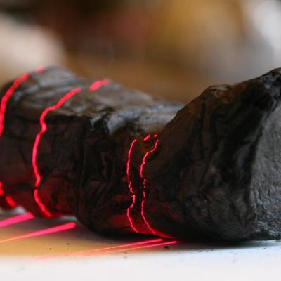 Herculaneum scroll with red laser lines being scanned at Institut de France by Brent Seales and his team. (copyright: EduceLab)