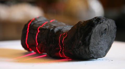Herculaneum scroll with red laser lines being scanned at Institut de France by Brent Seales and his team. (copyright: EduceLab)